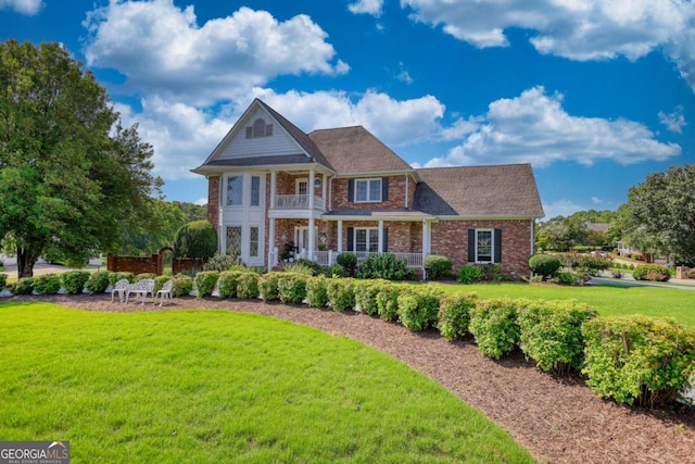 view of front of house featuring a balcony and a front lawn