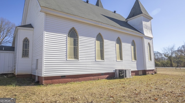 view of property exterior featuring central AC and a lawn