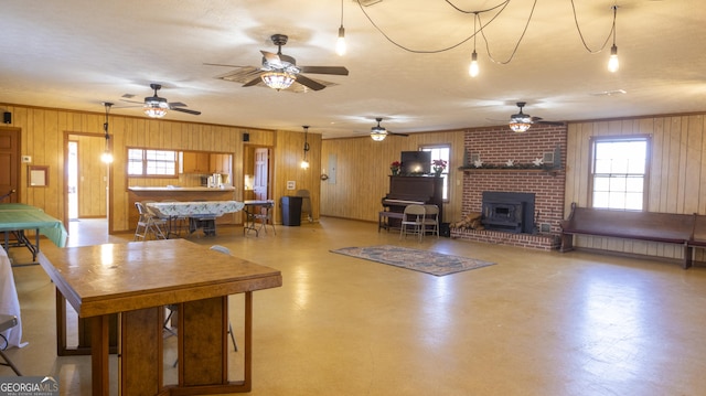 living room featuring a textured ceiling, a wood stove, and wood walls