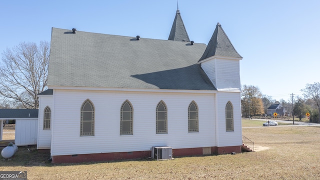 rear view of property with cooling unit and a yard