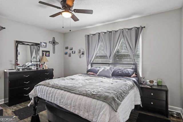 bedroom with ceiling fan and dark wood-type flooring