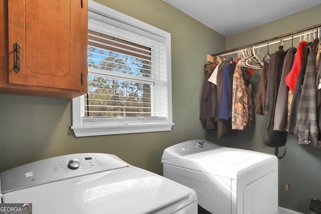 laundry area with cabinets, independent washer and dryer, and a textured ceiling