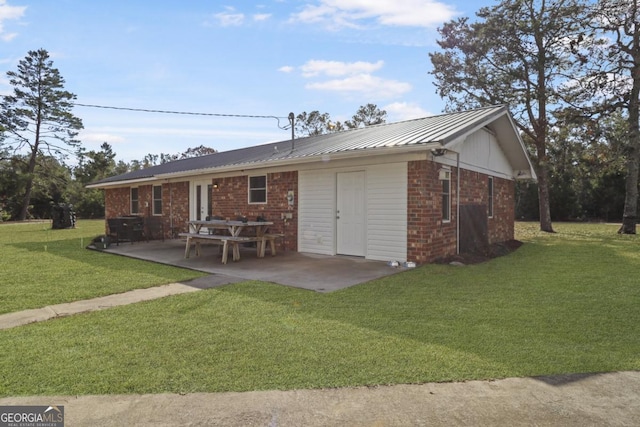 rear view of property featuring a lawn and a patio