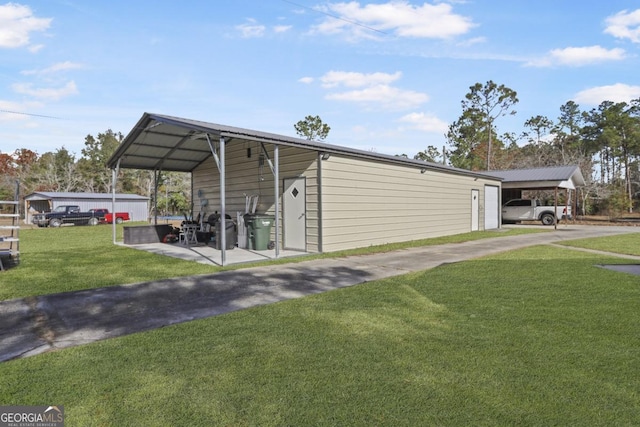 view of outdoor structure with a carport and a lawn