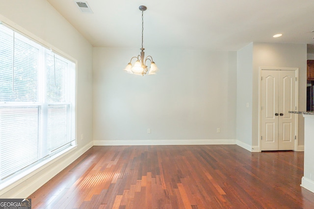 unfurnished room featuring dark hardwood / wood-style flooring and a chandelier