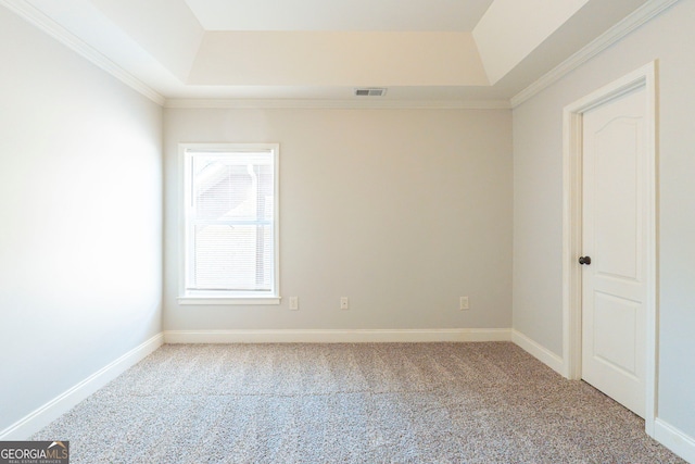 carpeted spare room with ornamental molding and a tray ceiling