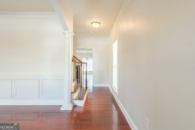 corridor with dark wood-type flooring and ornate columns