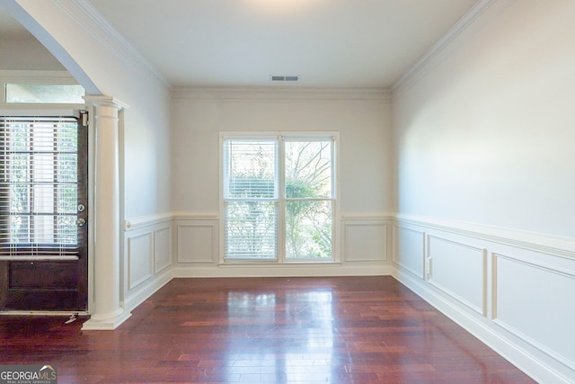 unfurnished room featuring dark hardwood / wood-style floors, ornamental molding, a wealth of natural light, and ornate columns