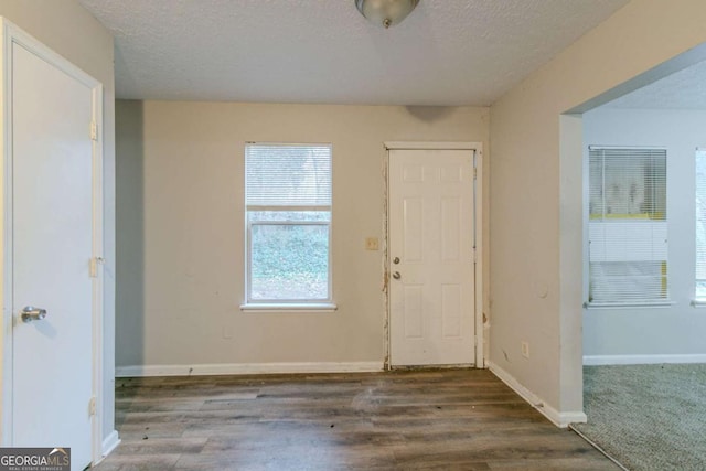 entrance foyer featuring a textured ceiling and dark wood-type flooring