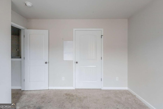 unfurnished bedroom featuring light carpet