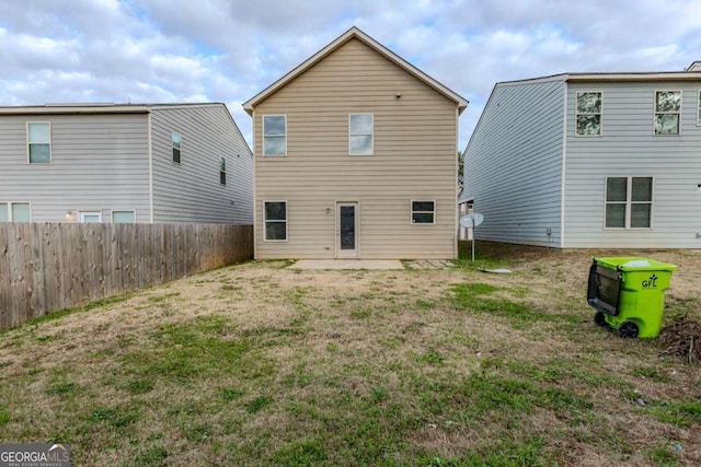 back of house with a patio area and a lawn