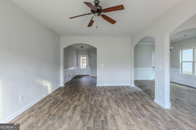 unfurnished room featuring ceiling fan, a healthy amount of sunlight, wood-type flooring, and crown molding