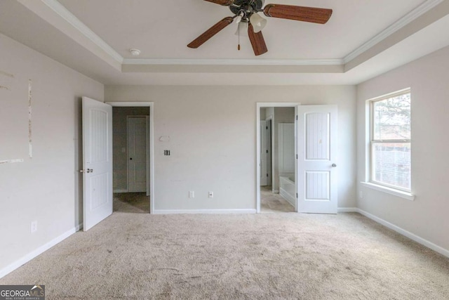 unfurnished bedroom featuring light carpet, a tray ceiling, ceiling fan, and ornamental molding