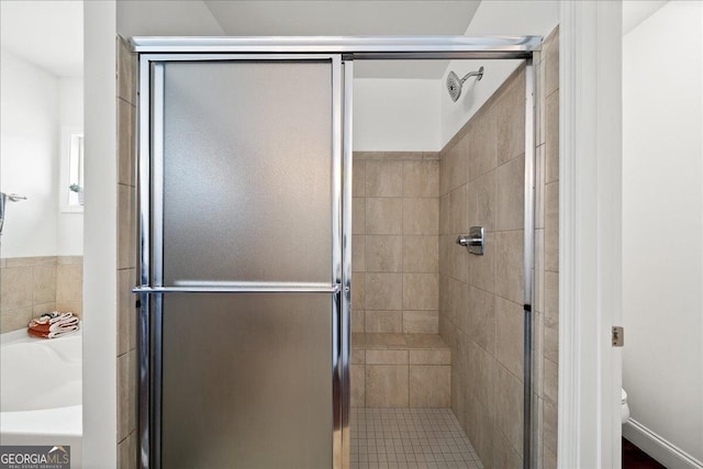 bathroom featuring separate shower and tub and toilet