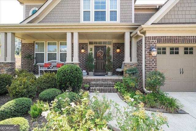 view of exterior entry with covered porch and a garage