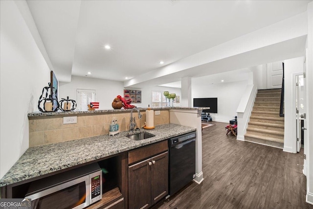 kitchen featuring light stone countertops, dark brown cabinets, dark wood-type flooring, sink, and black dishwasher