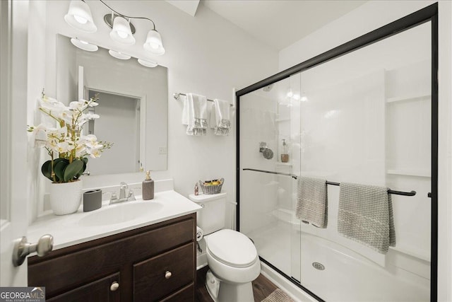 bathroom with vanity, toilet, and an enclosed shower