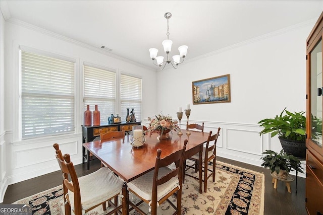 dining space with hardwood / wood-style flooring, a notable chandelier, and crown molding