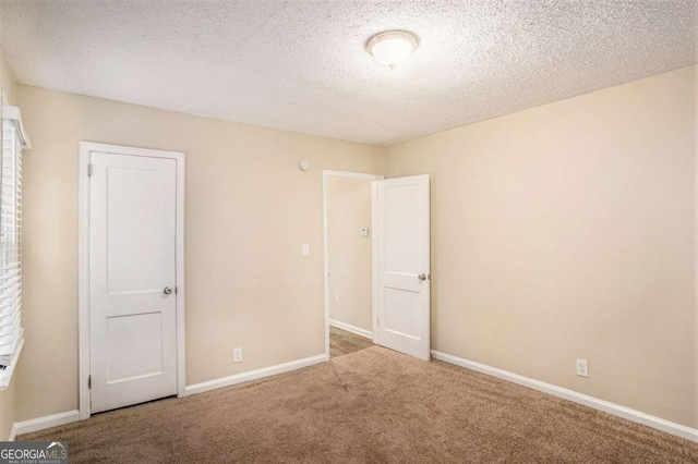 carpeted empty room with a textured ceiling