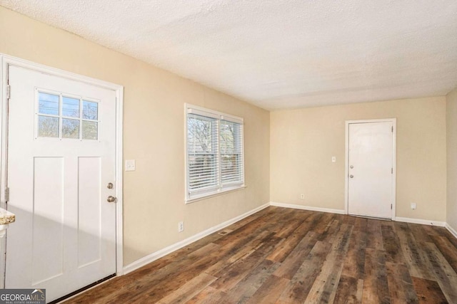 foyer entrance featuring dark hardwood / wood-style flooring and a textured ceiling