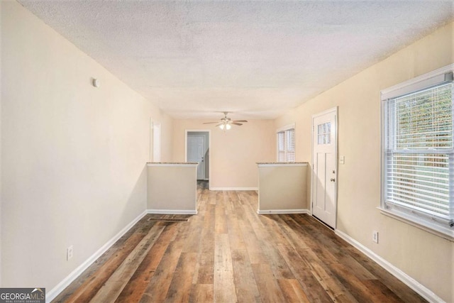 empty room featuring ceiling fan, wood-type flooring, and a textured ceiling