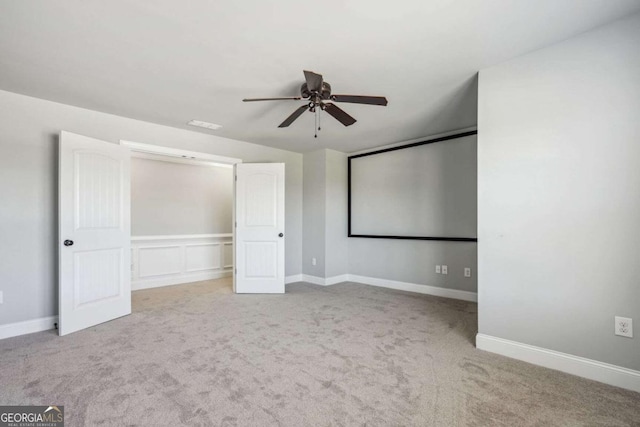 home theater room featuring ceiling fan and light carpet