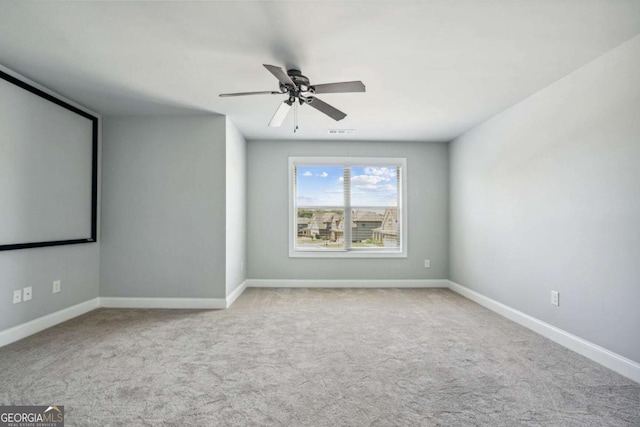 carpeted spare room featuring ceiling fan