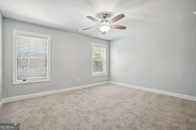 carpeted empty room featuring plenty of natural light and ceiling fan