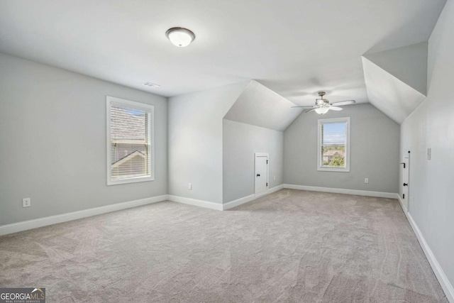 bonus room featuring a healthy amount of sunlight, lofted ceiling, and light carpet