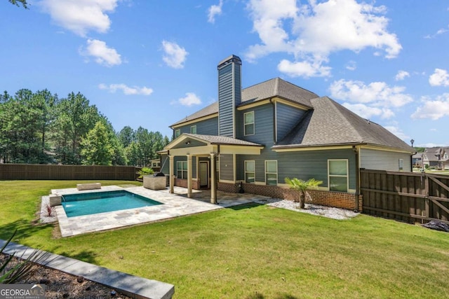 back of house with a fenced in pool, a yard, and a patio