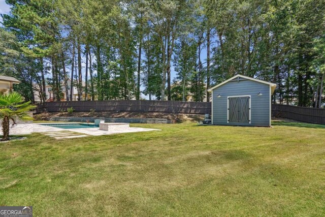 view of yard featuring a storage shed and a fenced in pool