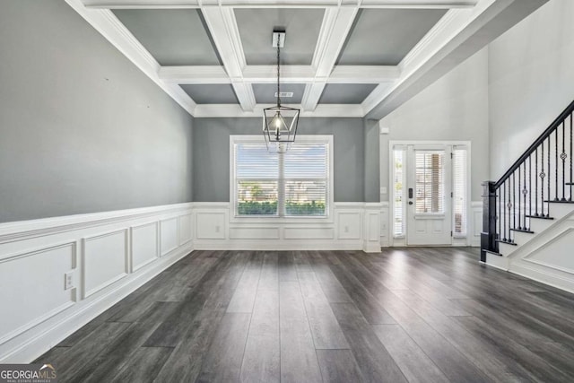 unfurnished dining area with beam ceiling, crown molding, dark wood-type flooring, and coffered ceiling