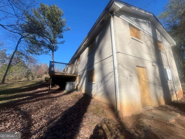 view of home's exterior with central AC and a deck