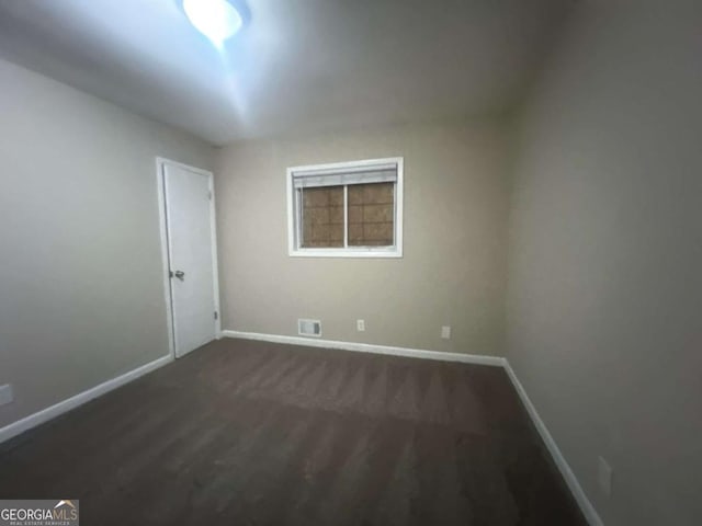 unfurnished room with dark hardwood / wood-style floors