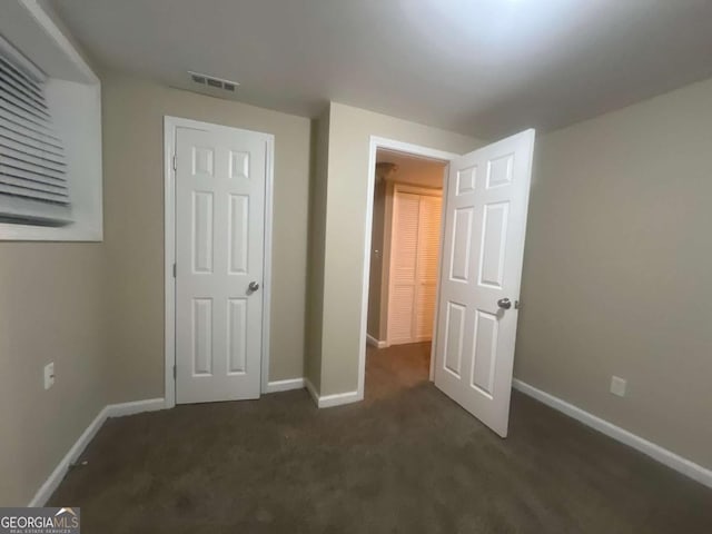 unfurnished bedroom featuring dark carpet