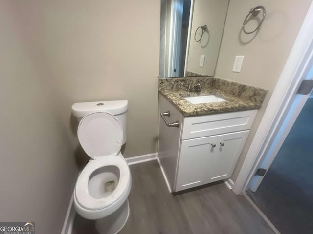 bathroom with vanity, wood-type flooring, and toilet