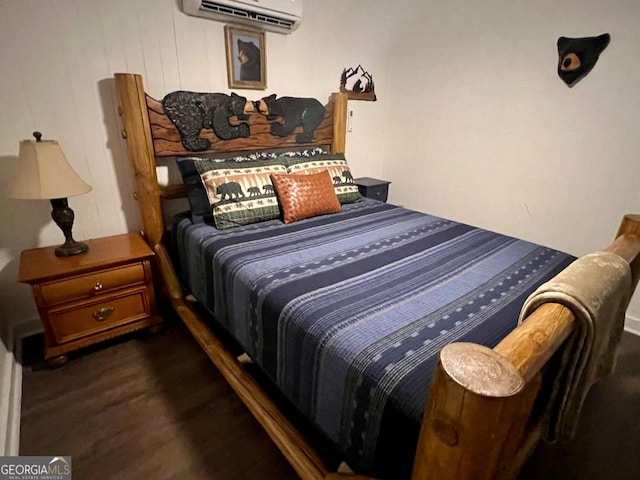 bedroom featuring a wall mounted AC and dark hardwood / wood-style flooring