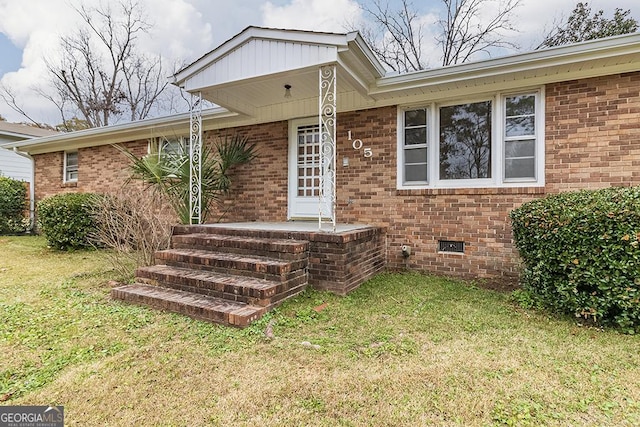 doorway to property featuring a lawn