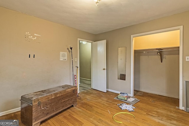 bedroom with light hardwood / wood-style floors and a closet