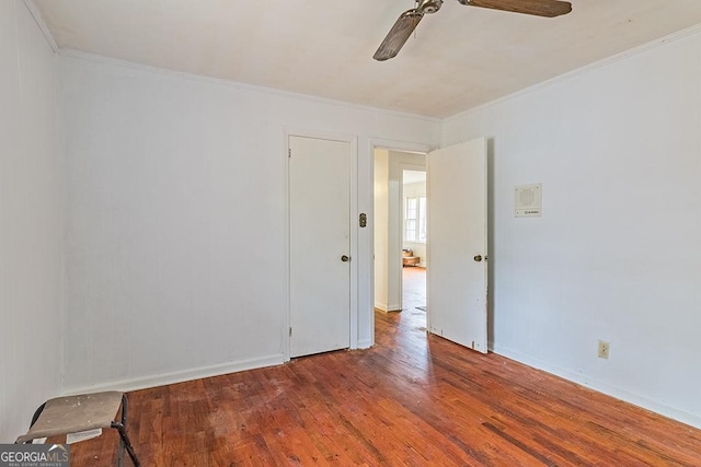 empty room with ceiling fan, hardwood / wood-style floors, and crown molding