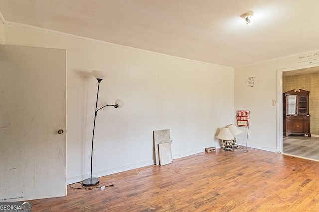 unfurnished room featuring hardwood / wood-style flooring and crown molding