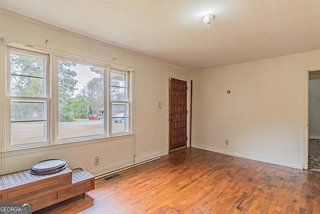 unfurnished room with hardwood / wood-style floors and ornamental molding