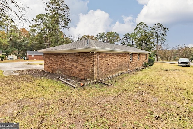 view of side of home with a yard