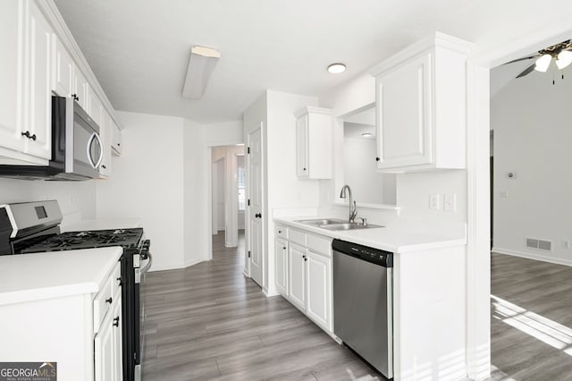 kitchen featuring appliances with stainless steel finishes, sink, light hardwood / wood-style flooring, white cabinetry, and ceiling fan