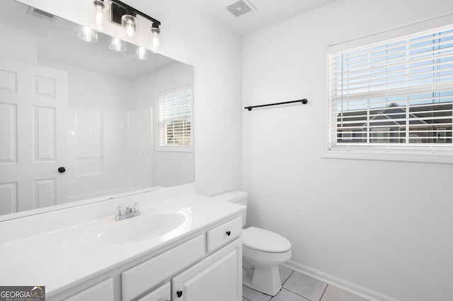 bathroom with vanity, tile patterned flooring, toilet, and walk in shower