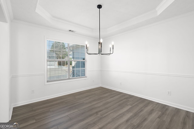 unfurnished dining area with a tray ceiling, dark wood-type flooring, crown molding, and a chandelier