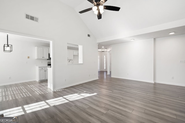 unfurnished living room with ceiling fan, high vaulted ceiling, and wood-type flooring