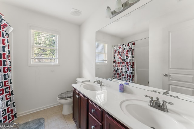 bathroom with tile patterned flooring, plenty of natural light, toilet, and vanity