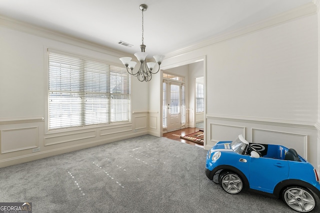 unfurnished dining area with carpet, an inviting chandelier, and crown molding