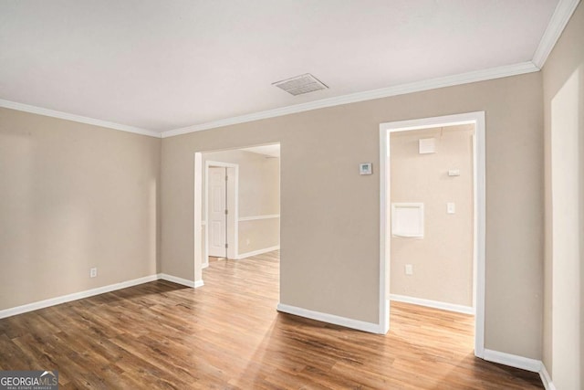 empty room with ornamental molding and hardwood / wood-style flooring